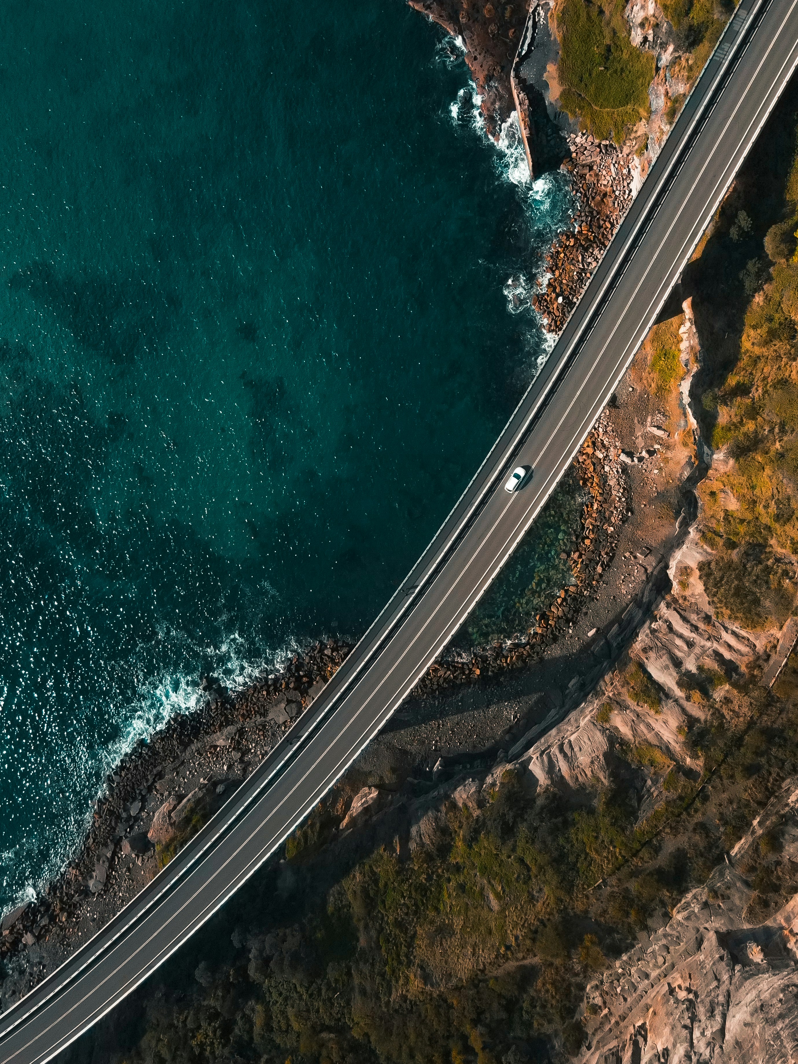 Aerial view of a coastal bridge hugging the Australian shoreline